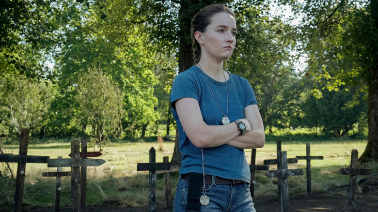 Abby standing in a graveyard with her arms crossed in The Last of Us