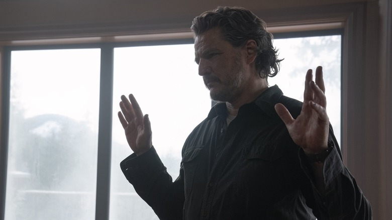 Joel holding up his hands in surrender in The Last of Us