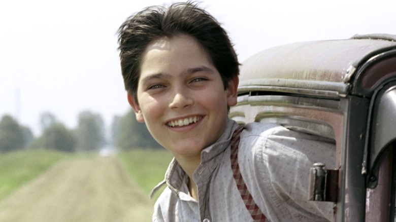Michael Sullivan Jr. smiling while sticking his head out a car in Road to Perdition