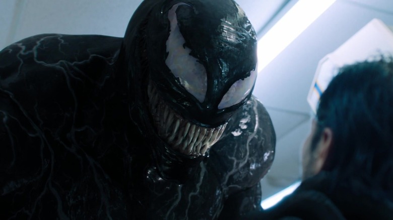 Venom towering over a thug in Venom