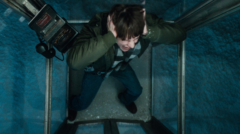Mason Thames as Finn holding his ears and screaming in the phone booth in the snow in Black Phone 2