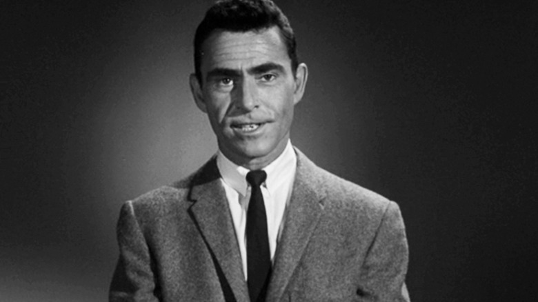 Rod Serling stands against a plain background in The Twilight Zone