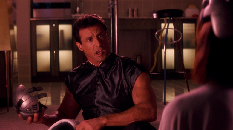 Sylvester Stallone as John Spartan holding a metallic object in Demolition Man