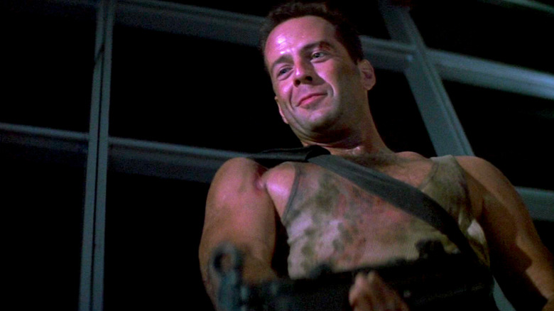 John McClane smirks while holding a gun