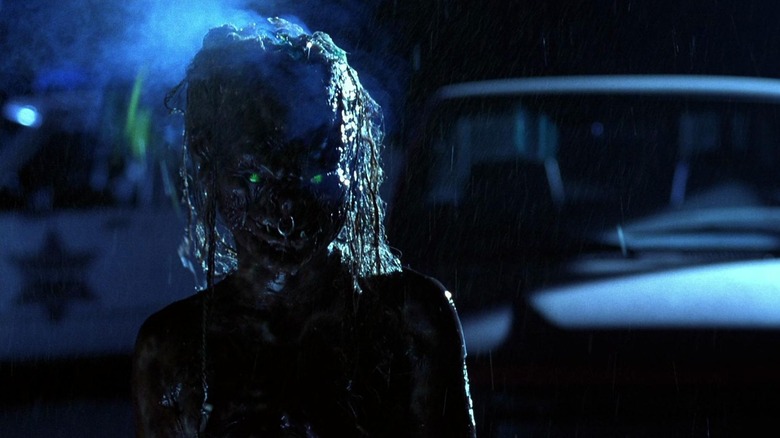 A demon standing outside of the house in the rain in Tales from the Crypt: Demon Knight