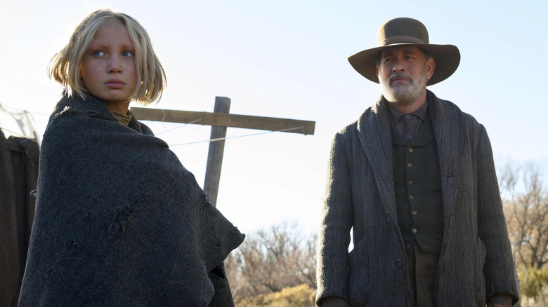 Johanna and Captain Kidd outdoors next to a cross-shaped pole in News of the World