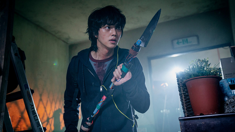 Cha Hyun-su (Song Kang) holds a makeshift spear in Sweet Home