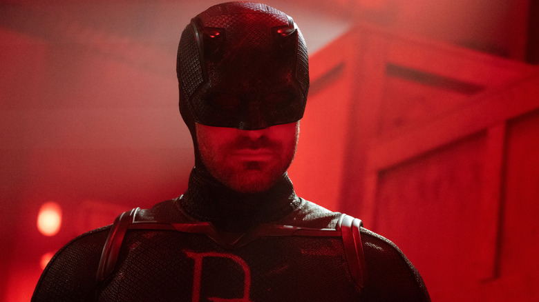 Charlie Cox as Daredevil in his black suit bathed in red light in Daredevil: Born Again