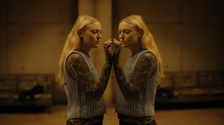 Dakota Fanning as Mina staring at her reflection in a one-way mirror in The Watchers