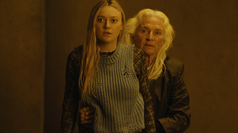 Olwen Fouéré's Madeline protective holds Dakota Fanning's Mina from behind during a tense scene in The Watchers