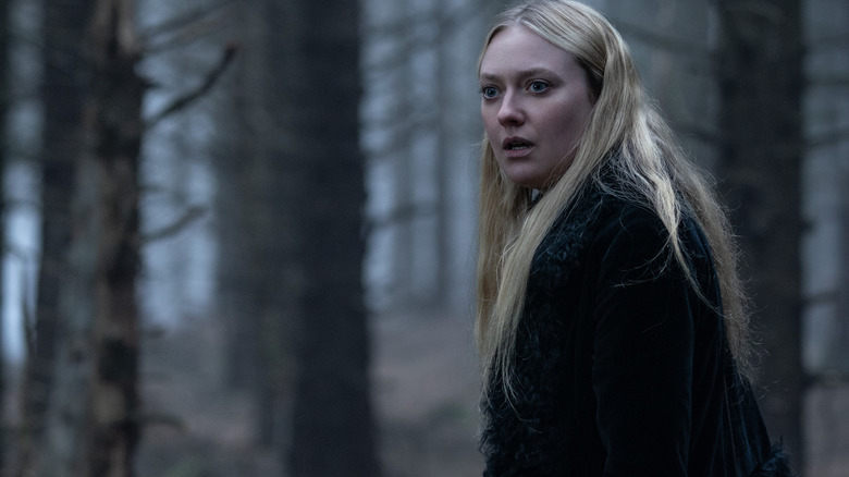 Dakota Fanning as Mina in the middle of the forest looking off-screen with a horrified expression in The Watchers