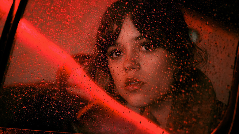 Jenna Ortega as Anima staring outside of a rain-soaked window in Hurry Up Tomorrow
