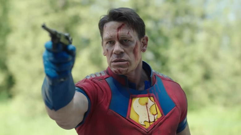 John Cena as Peacemaker, aiming a pistol in Peacemaker