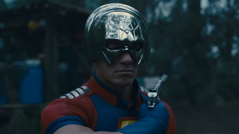 John Cena as Peacemaker, aiming a pistol over his shoulder in The Suicide Squad