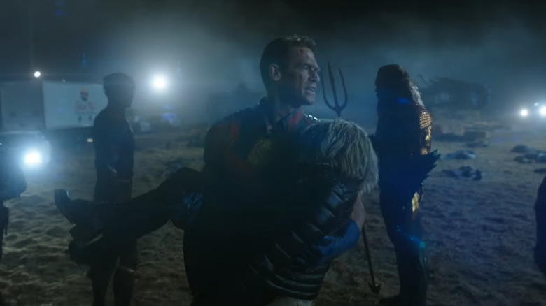 Peacemaker carries Harcourt away from The Flash and Aquaman in Peacemaker