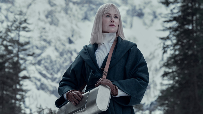 Masha on a mountaintop in a coat carrying a canister in Nine Perfect Strangers