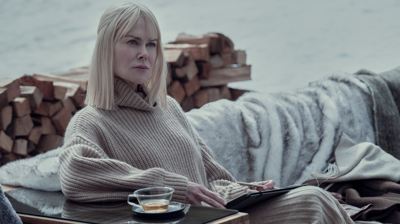 Masha sitting on an outdoor lounge writing in a journal in Nine Perfect Strangers