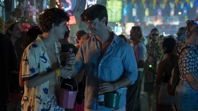 Lochlan and Saxon laughing at the full-moon party in The White Lotus