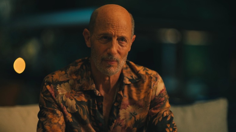 Greg in a flower print shirt looking at someone on The White Lotus