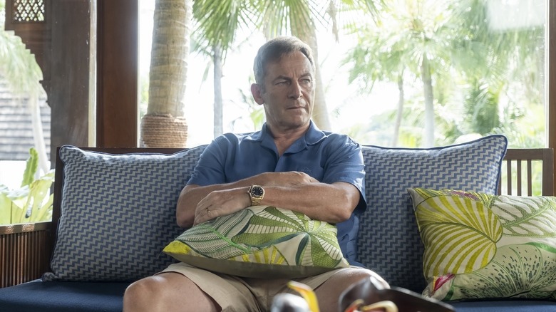 Timothy hugging a pillow and sitting on the couch in The White Lotus