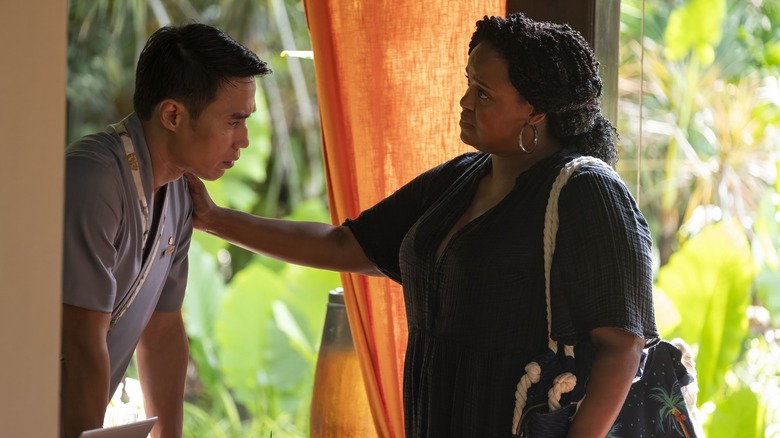 Belinda putting a hand on a sad Pornchai's shoulder in The White Lotus