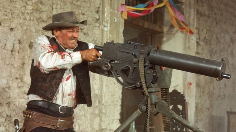 Pike Bishop (William Holden) takes hold of a machine gun in The Wild Bunch (1969)