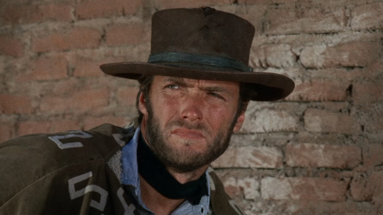 Clint Eastwood's Man with No Name is seen standing against a brick wall in For a Few Dollars More