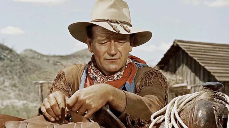 John Wayne's Hondo Lane looks forlorn as he rests on a saddle in Hondo
