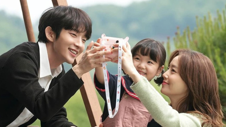 Baek Hee-sung (Lee Joon-gi) and Cha Ji-won (Moon Chae-won) take a picture with their daughter in Flower of Evil