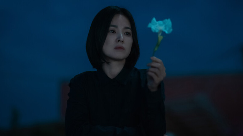 Moon Dong-eun (Song Hye-kyo) holds a flower in The Glory