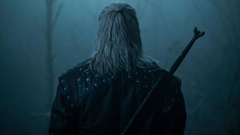 Liam Hemsworth as Geralt of Rivia shown from the back in a foggy forest in The Witcher season 4