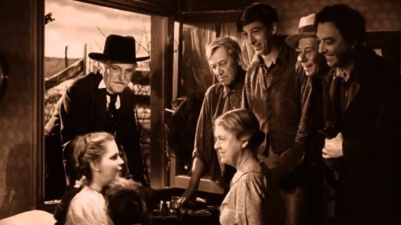 Wizard of Oz ending - Dorothy in bed surrounded by Professor Marvel, Uncle Herry, Auntie Em, Hunk, Hickory and Zeke