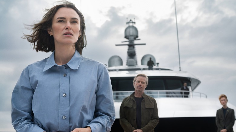 Lo stands at the front of the ship with Richard Bulmer behind her in The Woman in Cabin 10