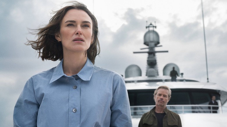 Lo stands at the front of the ship with Richard Bulmer behind her in The Woman in Cabin 10