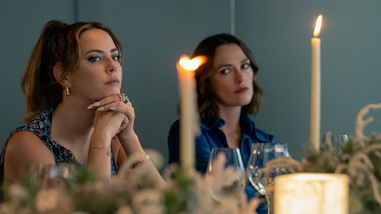 Grace and Lo at a dinner with candles on the table in The Woman in Cabin 10