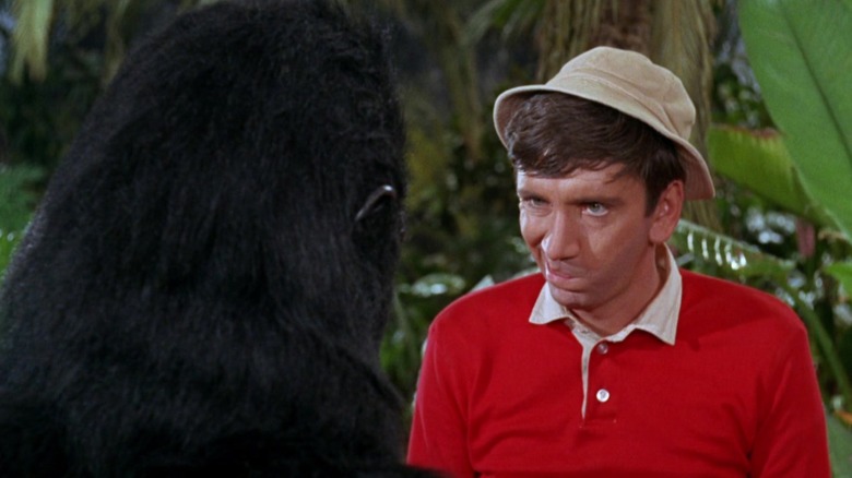 Gilligan fazendo careta para um cara com uma fantasia de gorila surrada