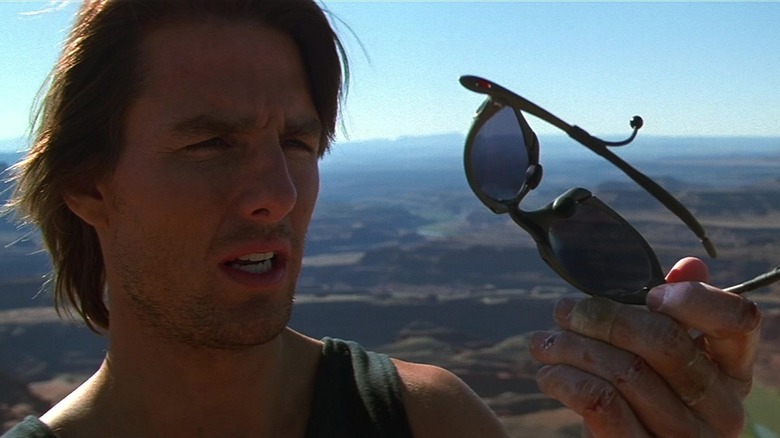 Ethan Hunt en la cima de una montaña, paralizado por un par de gafas de sol.