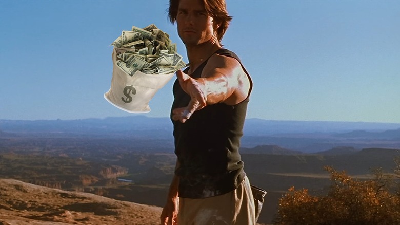 Tom Cruise as Ethan Hunt throwing a bag of money in Mission: Impossible 2