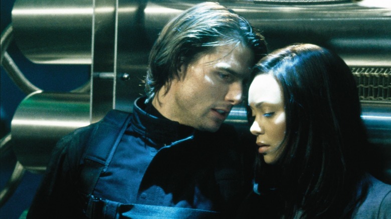 Tom Cruise's Ethan Hunt speaking closely with Thandie Newton's Nyah Hall in Mission: Impossible 2