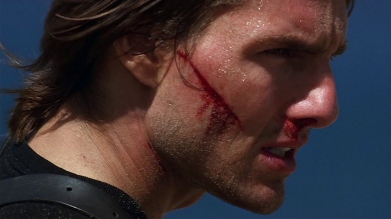 Tom Cruise's Ethan Hunt with a cut on his cheek in Mission: Impossible 2