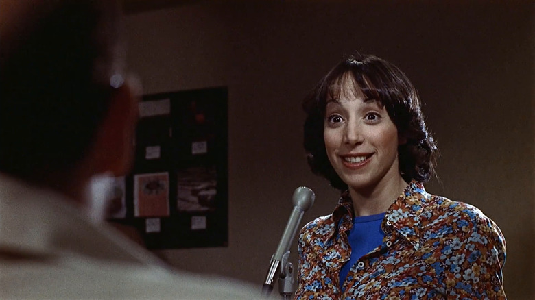 Laurie looking excited while standing at a mic in You Light Up My Life