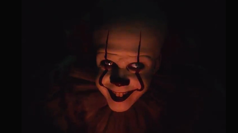 Pennywise's face illuminated in the dark in "It: Chapter Two"