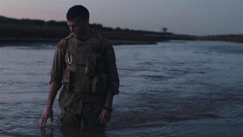 Alden Ehrenreich standing in river