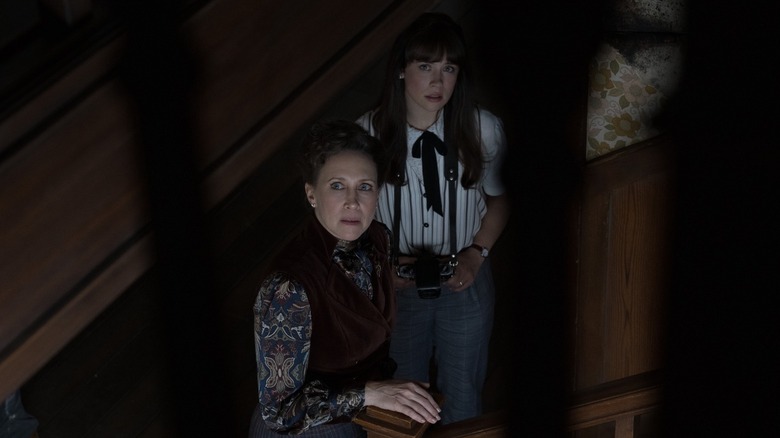 Lorraine and Judy Warren standing on stairs together looking up toward the camera in The Conjuring: Last Rites