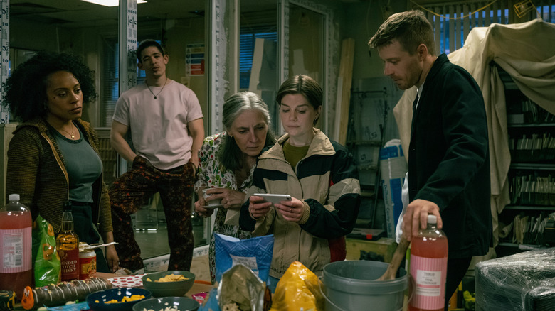 Rosalind Eleazar as Louisa, Christopher Chung as Roddy, Saskia Reeves as Standish, Aimee-Ffion Edwards as Shirley, and Jack Lowden as River reading a message in the office in Slow Horses season 5, episode 1
