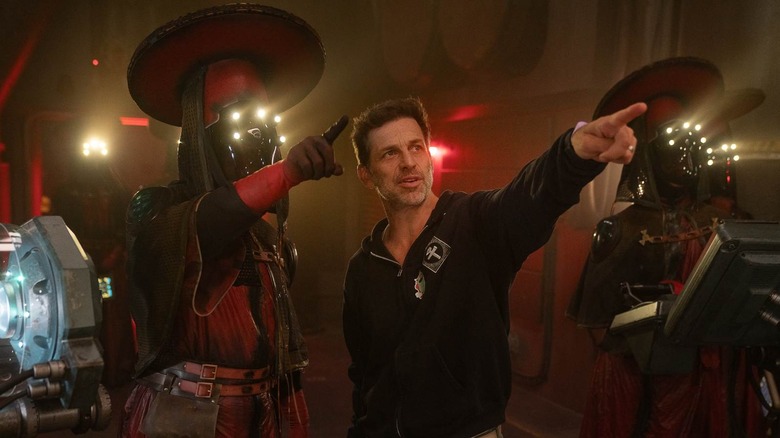 Zack Snyder on the set of Rebel Moon directing an actor dressed as an alien