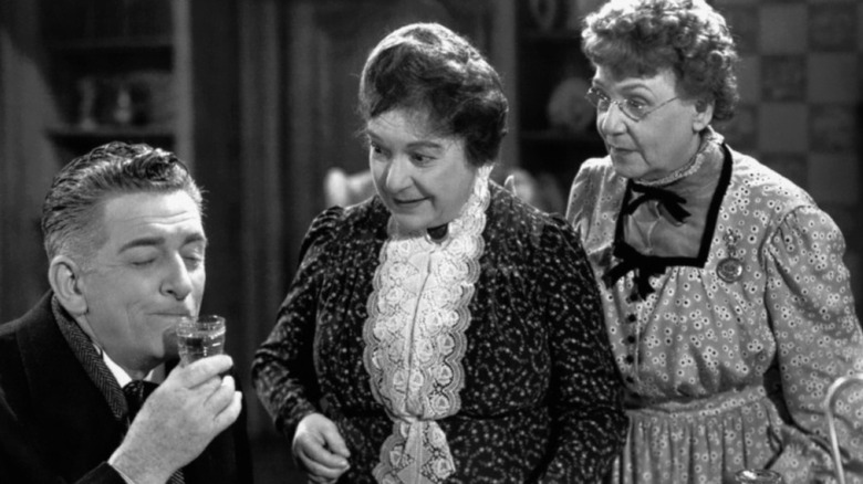 Mr. Witherspoon about to drink wine as Aunt Abby and Martha look on in Arsenic and Old Lace