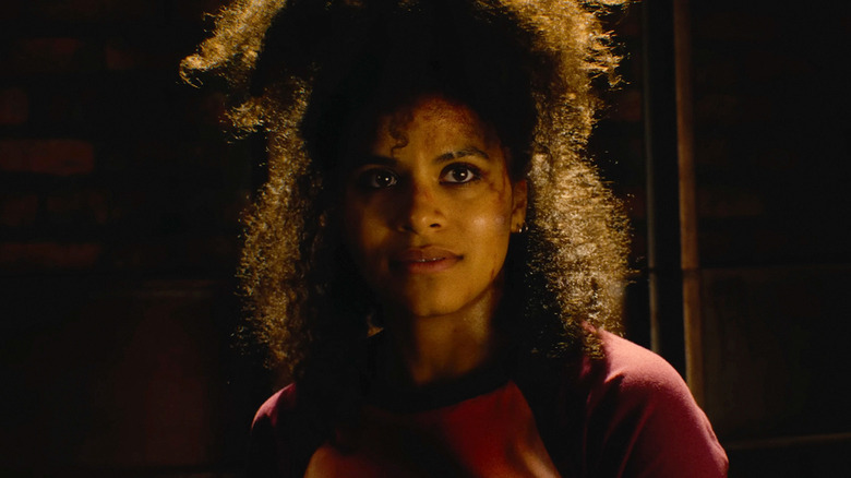 Zazie Beetz as Asia standing in the dark and backlit in They Will Kill You