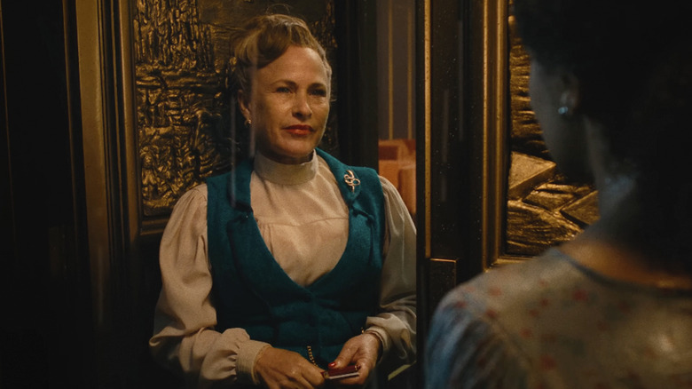 Patricia Arquette as Lilith greeting Asia at the door in the rain in They Will Kill You