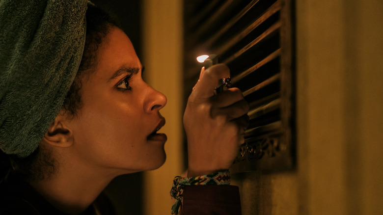 Asia holds a lighter to a vent in They Will Kill You